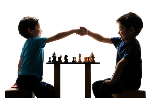 Two Half Asian Brothers shaking hands after chess