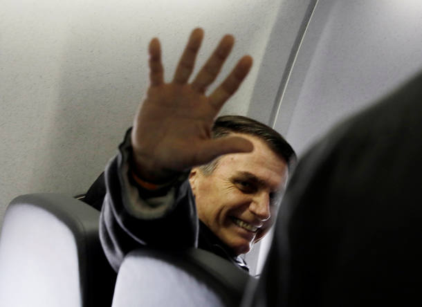 Presidential candidate Jair Bolsonaro waves on board his flight from Sao Paulo to Rio de Janeiro, Brazil September 29, 2018.  REUTERS/Leonardo Benassatto