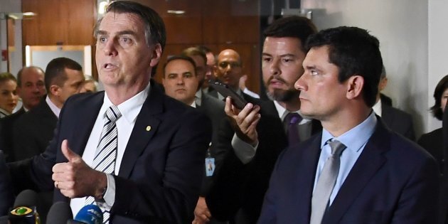 Brazilian President-elect Jair Bolsonaro (C) speaks with the press flanked by his future Chief of Staff Onyx Lorenzoni (L) and his Justice Minister Judge Sergio Moro, after a meeting with Attorney General Raquel Dodge in Brasilia, on November 20, 2018. (Photo by EVARISTO SA / AFP)        (Photo credit should read EVARISTO SA/AFP/Getty Images)
