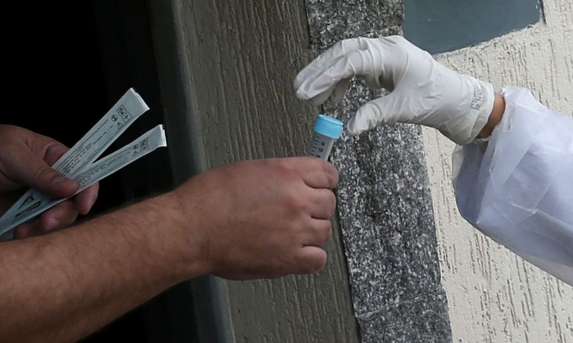 m homem recebe um teste de auto-coronavírus de um estudante de medicina à sua porta, em meio ao surto de doença de coronavírus (COVID-19), em São Caetano do Sul, São Paulo, Brasil, 14 de abril de 2020. REUTERS / Rahel Patrasso
