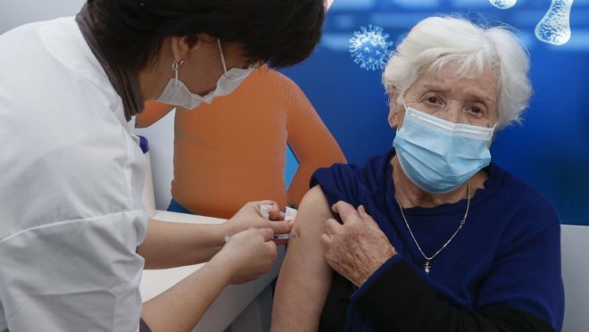 A Israeli healthcare worker vaccinates a woman against the COVID-19 coronavirus at Clalit Health Services, in the coastal city of Tel Aviv, on January 3, 2021. - Israel said two million people will have received a two-dose COVID-19 vaccination by the end of January, since the start on December 19, of an aggressive push to administer the vaccine made by US-German pharma alliance Pfizer-BioNTech. (Photo by JACK GUEZ / AFP)