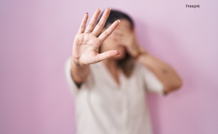 Blonde woman standing over pink background covering eyes with hands and doing stop gesture with sad and fear expression. embarrassed and negative concept.